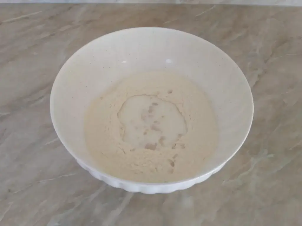 Mléko a droždí v důlku v mouce